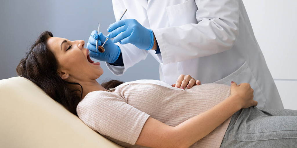 Стоматолог лечит зубы беременной девушке